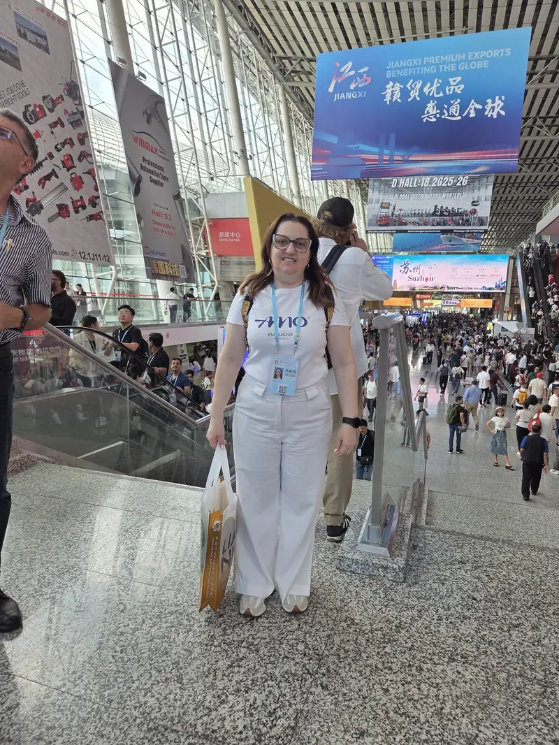 Jamila Umar (sócia AMO Embarque) na Canton Fair 2025, hall Suzhou ao fundo
